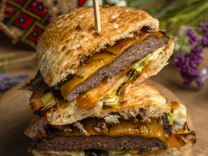 Plescaviță cu cheddar topit, sos BBQ și murături, la Trafika