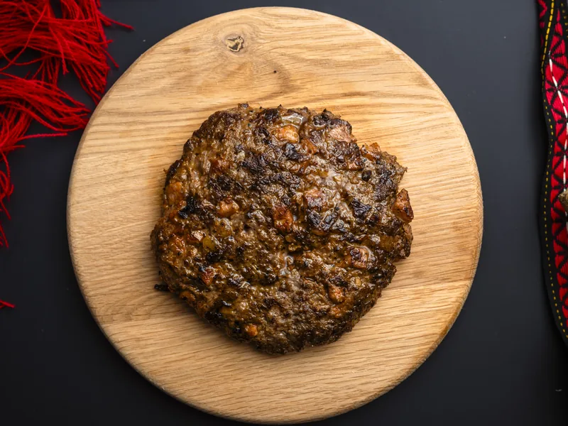 Plescaviță picantă la farfurie cu cașcaval și bacon, la Trafika